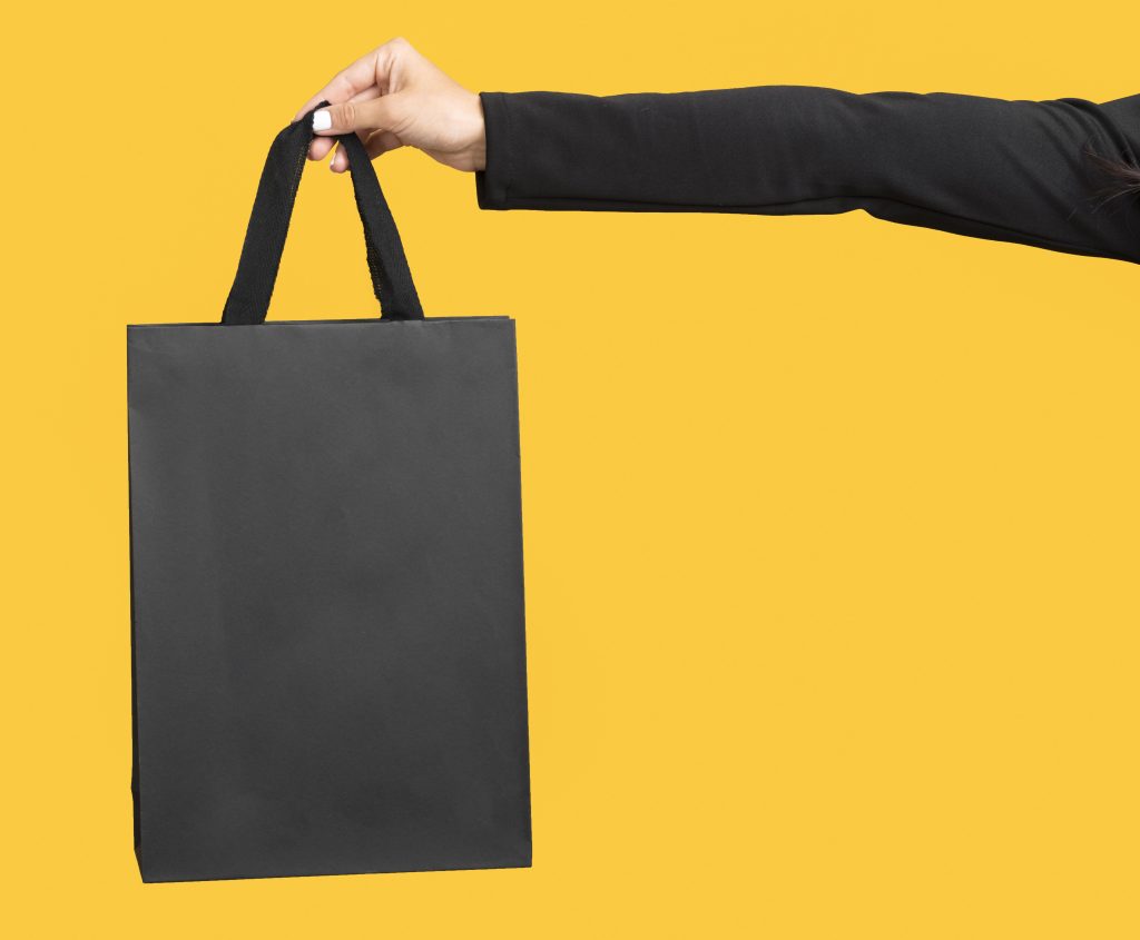 person-holding-big-black-shopping-bag-copy-space