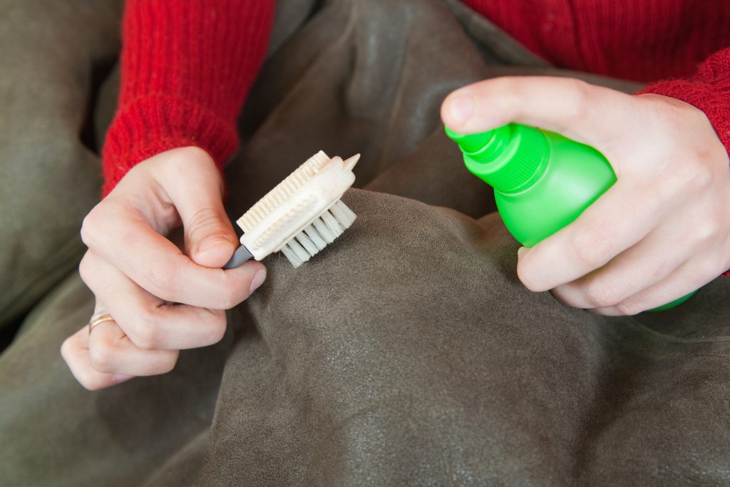 woman-cleaning-sheepskin-with-whisk-broom