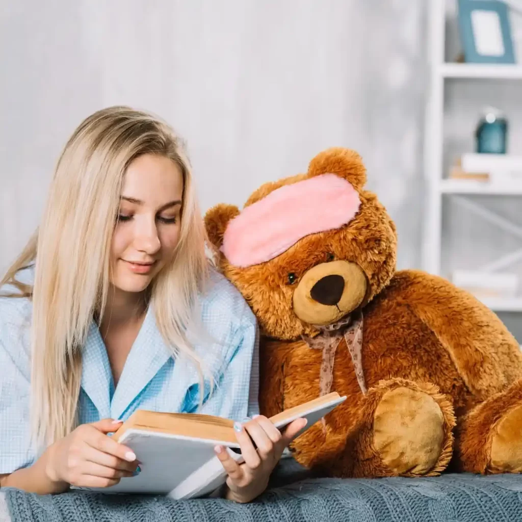 cute girl reading book with stuffed animal